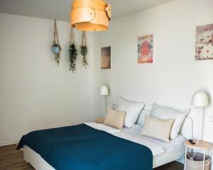 a bedroom with a large bed with a blue blanket at Ferienwohnung MainStyle - Hanau in Hanau am Main