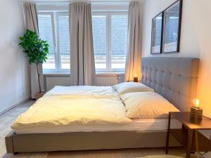 a bed in a bedroom with a large window at Danube Holiday Rooms in Krems an der Donau