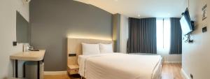 a bedroom with a bed and a desk and a window at V1 boutique hotel in Kanchanaburi City