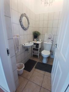 Un baño con inodoro, lavabo y espejo. en Beachfront Family Luxury Rental, en Swakopmund 38 fotos más