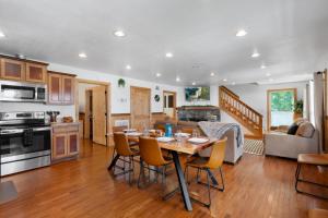 a kitchen and living room with a table and chairs at Trails End Cabin with a hot tub fire pit & indoor pool in Bryant