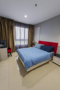a bedroom with a large bed with a red headboard at I City Prefect Homestay in Shah Alam