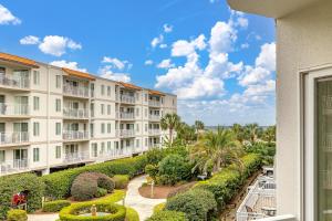 a view from the balcony of a building with bushes and trees at Beach Club #223 in Saint Simons Island