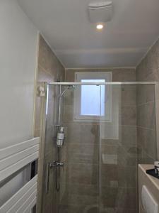 a shower with a glass door in a bathroom at Appartement cosy aux portes de Paris in Bois-Colombes