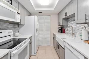 a kitchen with white cabinets and white appliances at Beach Club #224 in Saint Simons Island