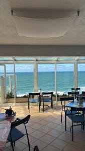 a room with tables and chairs and a view of the ocean at Albergaria Pedra D'Ouro in São Pedro de Moel