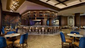 a restaurant with a bar with tables and chairs at Hard Rock Hotel & Casino Bristol in Bristol