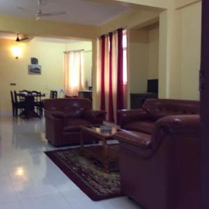 a living room with couches and a coffee table in it at Redrose Service Apartment in Kannur