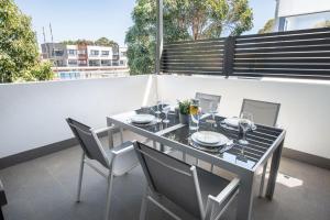 a dining table and chairs on a balcony at Chic Exec 2bdr 2bath -River,FREO,Parking,AC in Perth