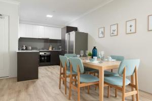 パースにあるBright Trendy 3br Apt - Walk To River & Shopsのテーブルと椅子のあるキッチンとダイニングルーム