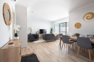 パースにあるModern Cozy Spacious 3 Bdrm 2bath,freo,parking,acのテーブルと椅子のあるダイニングルームとリビングルーム
