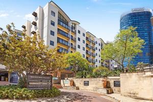 un cartello di fronte a un edificio alberato di Stylish City 1bdrm Apt Perth Heart 2 mins river a Perth