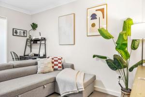 un soggiorno con un divano e una pianta di Stylish City 1bdrm Apt Perth Heart 2 mins river a Perth