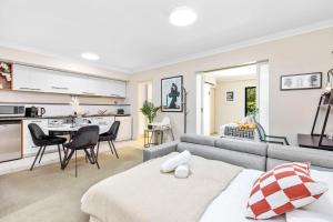 un soggiorno e una cucina con un divano e un tavolo di Stylish City 1bdrm Apt Perth Heart 2 mins river a Perth