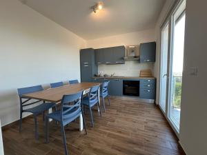 a kitchen with a wooden table and blue chairs at Bari San Francesco Mare in Bari