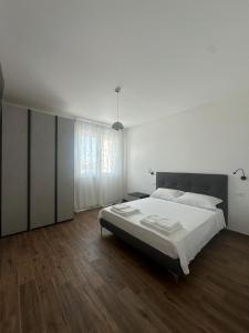 a white bedroom with a bed and a wooden floor at Bari San Francesco Mare in Bari