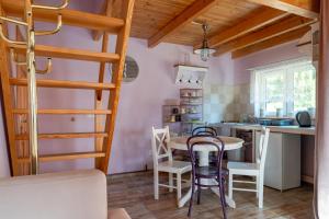 a kitchen with a table and chairs in a room at MorsoChatki - balia, sauna, garden party, plaża in Jelenia Góra