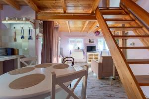 a kitchen and living room with a table and a staircase at MorsoChatki - balia, sauna, garden party, plaża in Jelenia Góra