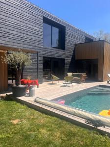 un cortile con piscina e una casa di Contemporary architect's house, pool, jacuzzi a Deauville
