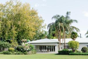 una casa blanca con palmeras delante en Soteria, en Upington