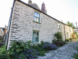 a brick building with a window on the side of it at Castle Hill Cottage in Middleham