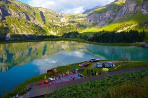 a group of people with umbrellas near a lake at Doppelbett im Schlafraum einer Alphütte in Bisisthal