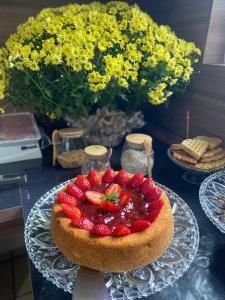 Un pastel con fresas y frutas sobre una mesa. en Hotel LENA, en São Luís Gonzaga