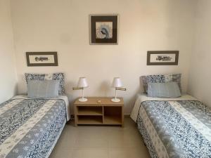ein Schlafzimmer mit zwei Betten und einem Nachttisch mit zwei Lampen in der Unterkunft Marina del Rey Costa Dorada TravelAddicts in El Morto de Barcelona + 15 Fotos