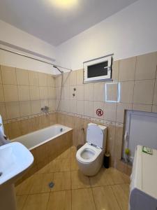 a bathroom with a toilet and a sink and a tub at Kolagji Rooms in Lukovë +56 photos