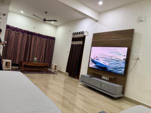 a bedroom with a large tv in the wall at LUXE Premium Service Appartment in Mysore