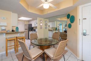 une salle à manger avec une table et des chaises en verre dans l'établissement Beach Club #308, à Île de Saint-Simon
