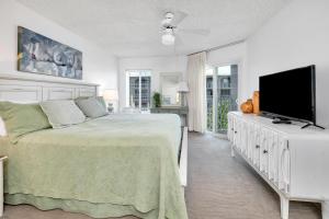 une chambre avec un lit et une télévision à écran plat dans l'établissement Beach Club #308, à Île de Saint-Simon