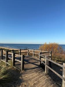 a wooden boardwalk leading to the beach at Cozy Seaside apartments in Carnikava