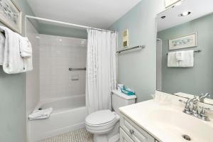 une salle de bain avec des toilettes blanches et un lavabo dans l'établissement Beach Club #308, à Île de Saint-Simon 8 autres photos