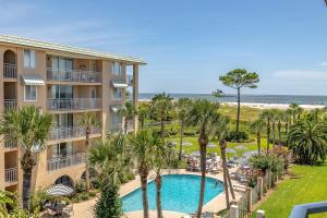 une vue aérienne d'un complexe avec piscine et palmiers dans l'établissement Beach Club #308, à Île de Saint-Simon