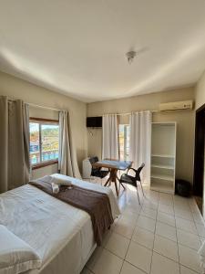 a bedroom with a bed and a table and a table at Hotel Enseada in São Francisco do Sul +11 photos