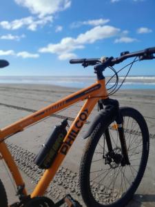 an orange bike parked on the beach at Rancho aparte duplex in San Clemente del Tuyú