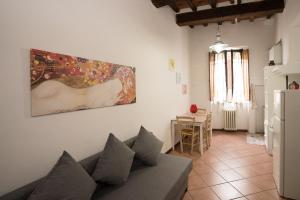 a living room with a couch and a painting on the wall at All'ombra della Torre only Rooms in Siena