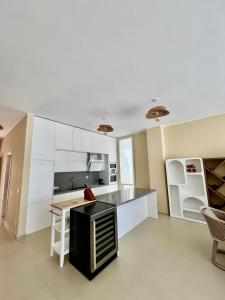 a kitchen with white cabinets and a black counter top at Elite Vila with Pool, Green Coast in Palasë +13 photos