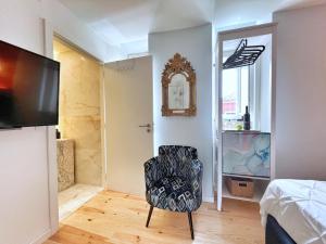 a living room with a chair and a television at Azzulea Rossio Suites in Lisbon
