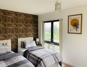 a bedroom with two beds and a window at Atom, Large 4 to 5 Bed House in East London, Sleeps 12, Garden, Parking, ideal for Contractors, Large Groups, Travellers in Barking