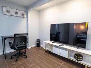 a living room with a chair and a large television at Studio Apt Lake Park Station Airport Hospital NJ NYC in Rahway