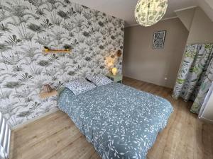 a bedroom with a bed with a floral wallpaper at Les Aurores Marines in Bray-Dunes