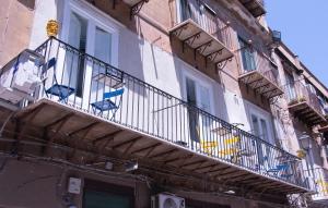 a balcony on the side of a building with chairs on it at San Carlo Cuore di Palermo in Palermo