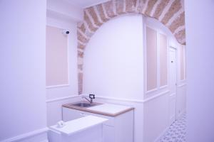 a white bathroom with a sink and an archway at San Carlo Cuore di Palermo in Palermo +63 photos