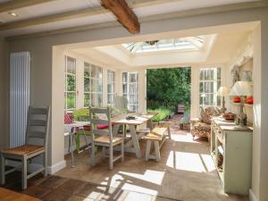 ein Anbau an einen Wintergarten mit Tisch und Stühlen in der Unterkunft Sunny Cottage in Grantham