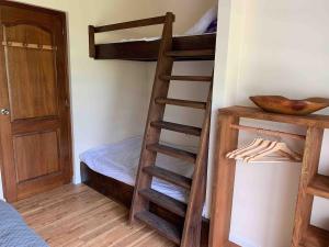 a room with two bunk beds and a ladder at Happy T Beach House in Haapiti +11 photos