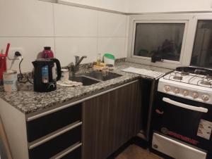 a kitchen with a sink and a stove at Saladillo Apart in Saladillo