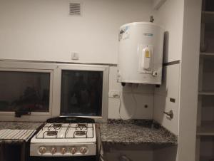 a kitchen with a stove and a water heater at Saladillo Apart in Saladillo
