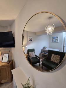 a mirror in a living room with a couch and chair at Galway City - 135 Bohermore in Galway
